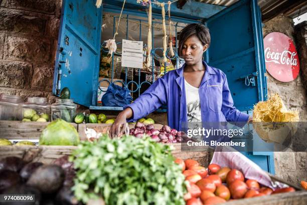 Silvia Gikuma, co-owner of a fresh-vegetable stall, puts garlic and onions on display at the stall in Nairobi, Kenya, on June 11, 2018....