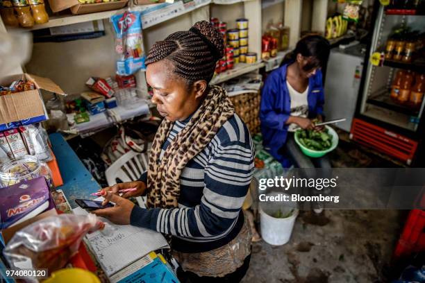 Janeffer Wacheke, left, and her sister Silvia Gikuma, co-owner's of a fresh-vegetable stall, work alongside each other on the stall in Nairobi,...