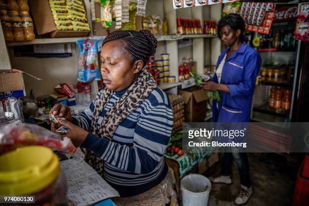 Janeffer Wacheke, left, and her sister Silvia Gikuma, co-owner's of a fresh-vegetable stall, work alongside each other on the stall in Nairobi,...