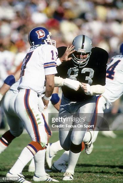 S: Linebacker Ted Hendricks of the Los Angeles Raiders in action cant get to quarterback Steve DeBerg of the Denver Broncos before he gets his pass...