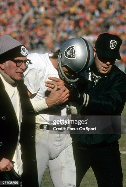 Wide Receiver Fred Biletnikoff of the Oakland Raiders is helped off the field by team docters circa early 1970's during an NFL football game....