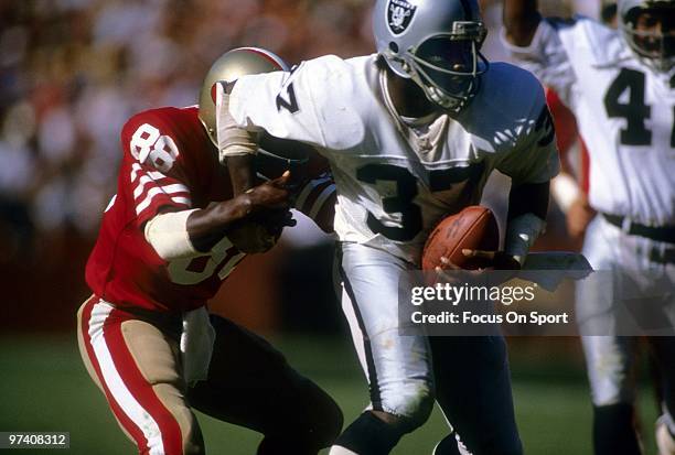 S: Defensive back Lester Hayes of the Oakland Raiders in action running back an interception tries to break away from wide receiver Freddie Solomon...