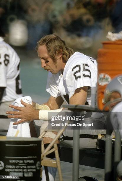 Wide Receiver Fred Biletnikoff of the Oakland Raiders sitting on the bench wiping the stickem off his hand circa early 1970's during an NFL football...