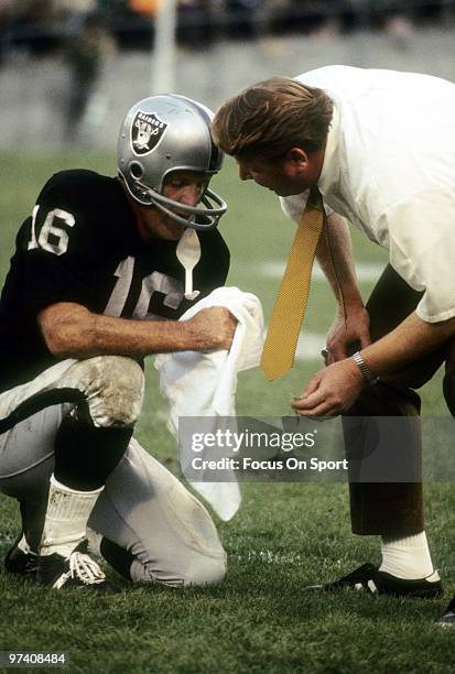 S: Quarterback/Kicker George Blanda and head coach John Madden of the Oakland Raiders talks strategy with one another on the sidelines during a circa...