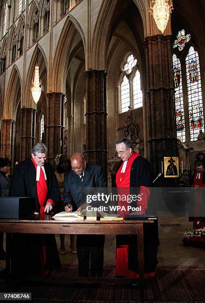 South Africa's President Jacob Zuma signs the visitors book alongside Reverend John Hall , the Dean of Westminster Abbey during his visit to lay a...