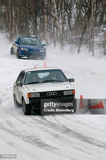 Audi and Subaru rally cars maneuver between cones on a snowy track at Team O'Neil Rally School in Dalton, New Hampshire, U.S., on Friday, Feb. 19,...