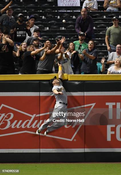 Corey Dickerson of the Pittsburgh Pirates crashes into the left field wall and cannot make a catch on a three run home run by Jake Lamb of the...