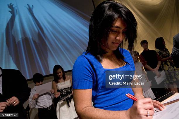 Liane Gazmeo, 16 signs her "True Love Waits" commitment certificate during a purity ring ceremony on February 13, 2008 at the Full Life Assembly of...