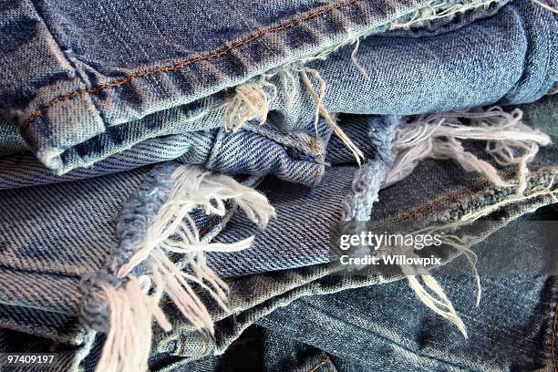 velho mangona jeans azuis em uma pilha de desarrumado - calças de ganga rasgadas imagens e fotografias de stock