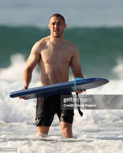 Mike Brown carries a surf board during the England recovery session held on the beach on June 14, 2018 in Umhlanga Rocks, South Africa.