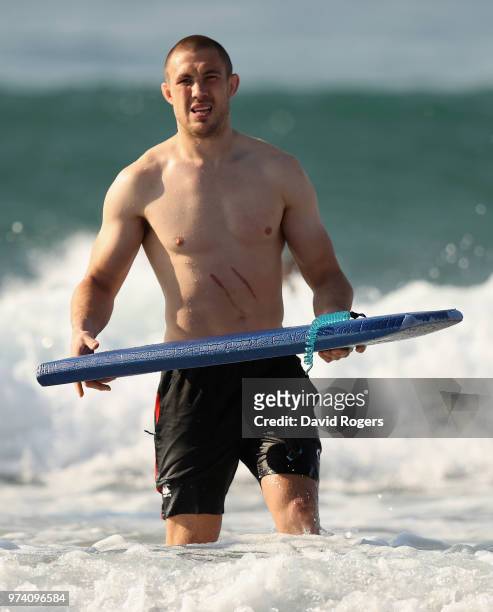 Mike Brown carries a surf board during the England recovery session held on the beach on June 14, 2018 in Umhlanga Rocks, South Africa.