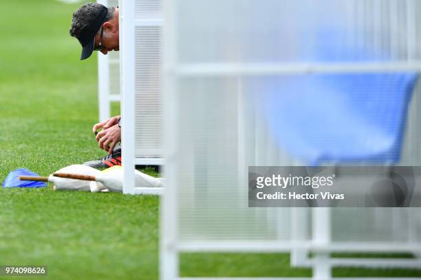 Juan Carlos Osorio, coach of Mexico, fasten his laces during a training session at team training base Novogorsk-Dynamo on June 14, 2018 in Moscow,...