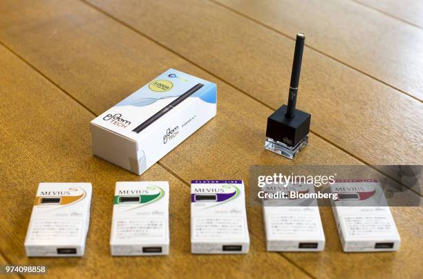 Japan Tobacco Inc.'s Ploom Tech smokeless tobacco device, top right, and capsules are arranged for a photograph at the company's headquarters in...