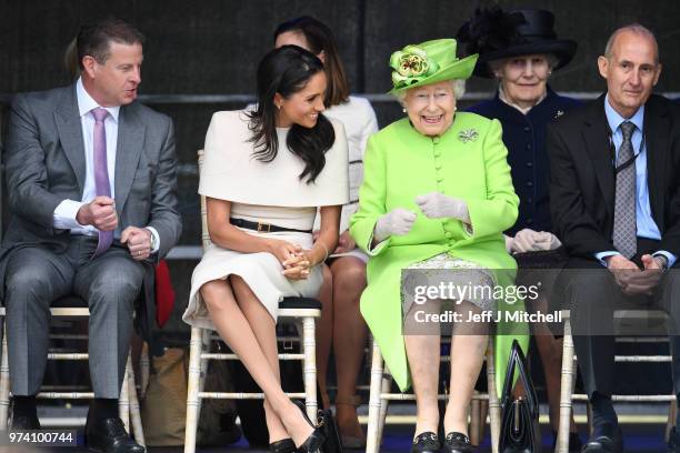 Queen Elizabeth II laughs with Meghan, Duchess of Sussex during a ceremony to open the new Mersey Gateway Bridge on June 14, 2018 in the town of...