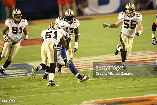 Jonathan Vilma of the New Orleans Saints tackles Pierre Garcon of the Indianapolis Colts during Super Bowl XLIV at Sun Life Stadium on February 7,...