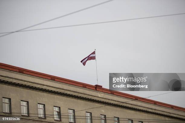 The Latvian national flag flies from the rooftop of a building in Riga, Latvia, on Wednesday, June 13, 2018. Latvia's plans to kick out risky cash...