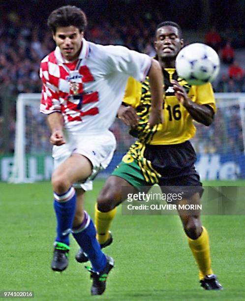 Croatian mid-fielder Aljosa Asanovic is challenged by Jamaican mid-fielder Robert Earle, who scored the 1-1 equalizer for his team, 14 June at the...