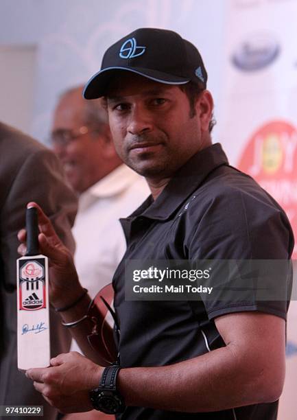 Indian cricketer Sachin Tendulkar holds a bat during an Joy of giving week event in Mumbai on Tuesday, March 2, 2010.