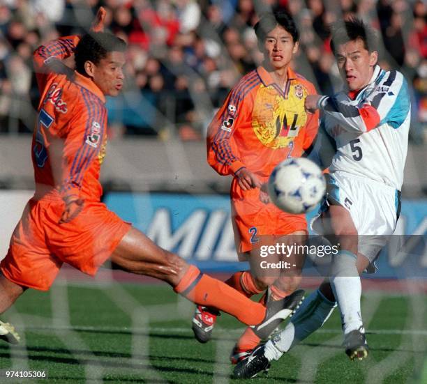 Captain of the soon-to-be-defunct Yokohama Flugels Motohiro Yamaguchi fires the ball past Shimizu S-Pulse midfielder Santos , from Brazil, as Shimizu...