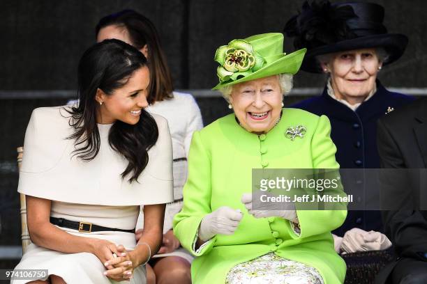 Queen Elizabeth II sitts and laughs with Meghan, Duchess of Sussex during a ceremony to open the new Mersey Gateway Bridge on June 14, 2018 in the...