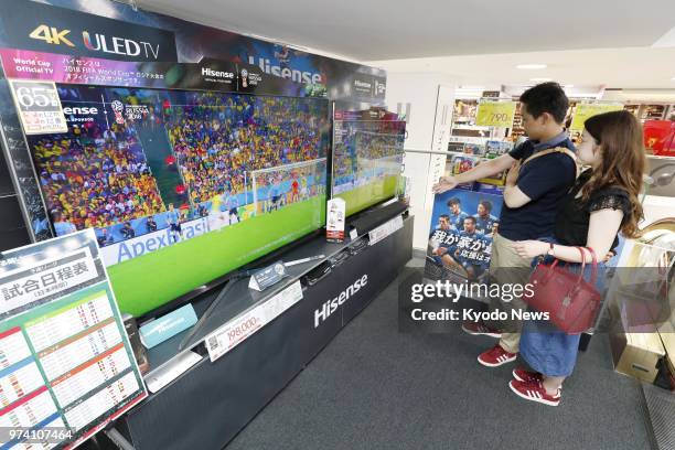 Shoppers examine TV sets at electronic appliance retailer Bic Camera's Yurakucho outlet in Tokyo on June 13, 2018. Retailers and manufacturers have...