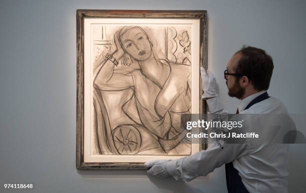 An art handler adjusts 'Portrait of Mrs Hutchinson' by Henri Matisse during a preview of the Impressionist and Modern sale at Sotheby's on June 14,...