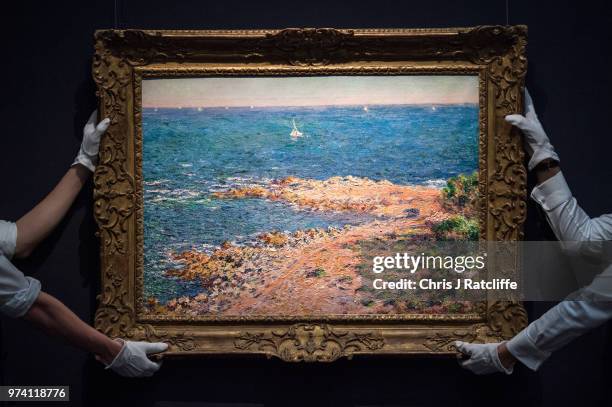 Two art handlers hang 'La Mediterranee par vent de mistral' by Claude Monet during a preview of the Impressionist and Modern sale at Sotheby's on...