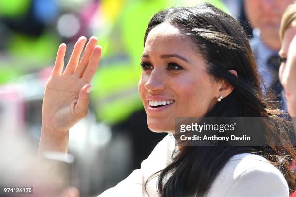 Meghan, The Duchess of Sussex waves as she joins Queen Elizabeth II to walk from Storyhouse to Chester Town Hall on June 14, 2018 in Chester,...