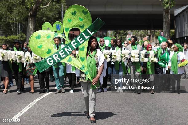 People hold tributes to Grenfell as they walk to the Wall of Truth to mark the one year anniversary of the Grenfell Tower fire on June 14, 2018 in...