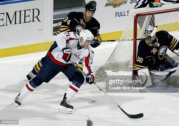 Brooks Laich of the Washington Capitals readies to take a backhand shot as Ryan Miller and Chris Butler of the Buffalo Sabres defend at HSBC Arena on...