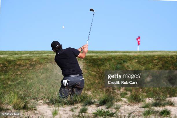 Phil Mickelson of the United States plays a shot from a bunker on the 11th hole during the first round of the 2018 U.S. Open at Shinnecock Hills Golf...