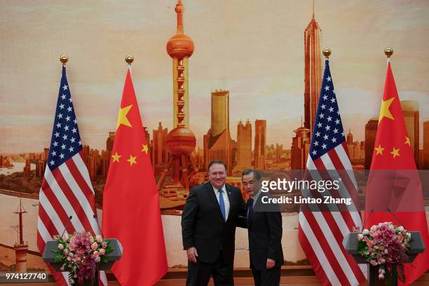 Chinese Foreign Minister Wang Yi shakes hands with U.S. Secretary of State Mike Pompeo during a press conference at the Great Hall of the People on...