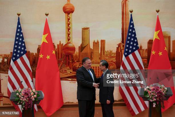 Chinese Foreign Minister Wang Yi shakes hands with U.S. Secretary of State Mike Pompeo during a press conference at the Great Hall of the People on...