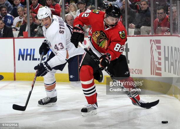 Tomas Kopecky of the Chicago Blackhawks approaches the puck as Jason Strudwick of the Edmonton Oilers watches from behind on March 03, 2010 at the...