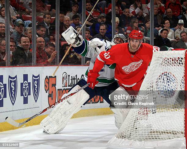 Drew Miller of the Detroit Red Wings tries to get around a falling Roberto Luongo of the Vancouver Canucks during an NHL game at Joe Louis Arena on...