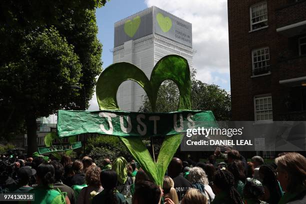 Members of the public hold banners as they take part in a procession to Grenfell tower as part of commemorations on the anniversary of the Grenfell...