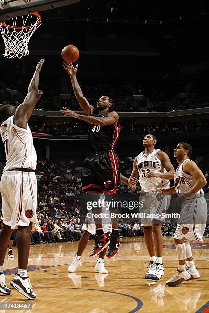 Udonis Haslem of the Miami Heat shoots a layup against DeSagana Diop, Boris Diaw and D.J. Augustin of the Charlotte Bobcats during the game at Time...