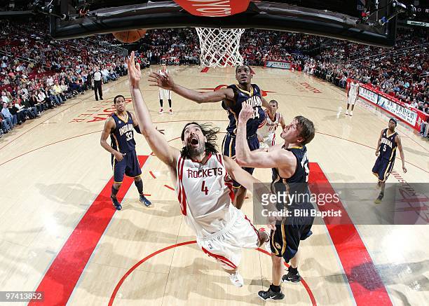 Luis Scola of the Houston Rockets shoots a layup against Troy Murphy and Solomon Jones of the Indiana Pacers during the game at Toyota Center on...
