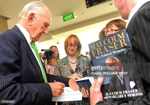 Former Australian prime minister Malcolm Fraser signs a copy of his first political memoirs at its launch at the University of Melbourne's Law School...