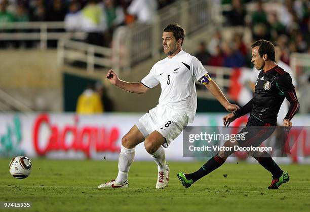 Gerardo Torrado of Mexico passes the ball past Tim Brown of New Zealand in the first half during their International Friendly match at the Rose Bowl...