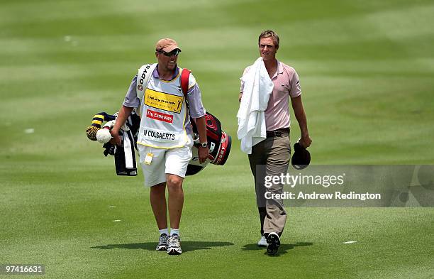 Nicolas Colsaerts of Belgium walks with his caddie on the 18th hole during the first round of the Maybank Malaysian Open at the Kuala Lumpur Golf and...