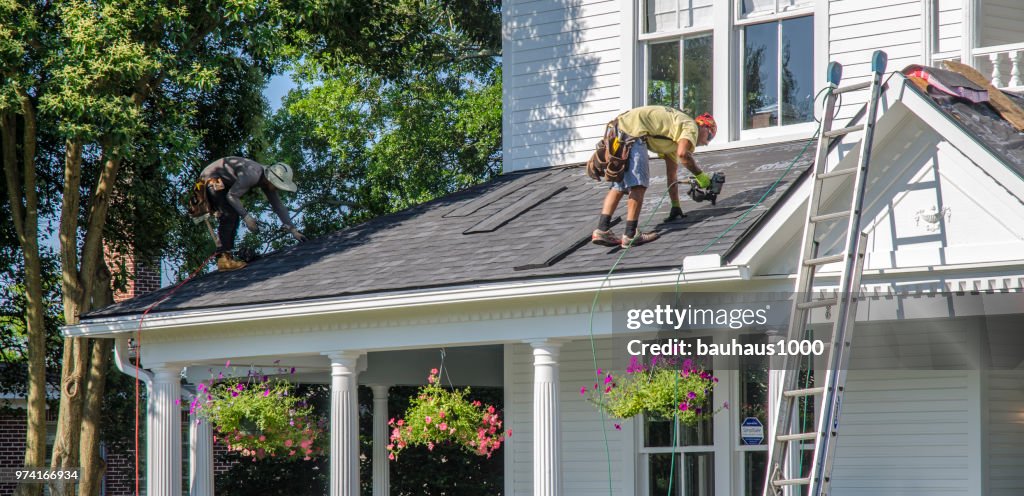 Roofing Contractors Replacing Damaged Roofs After a Hail Storm