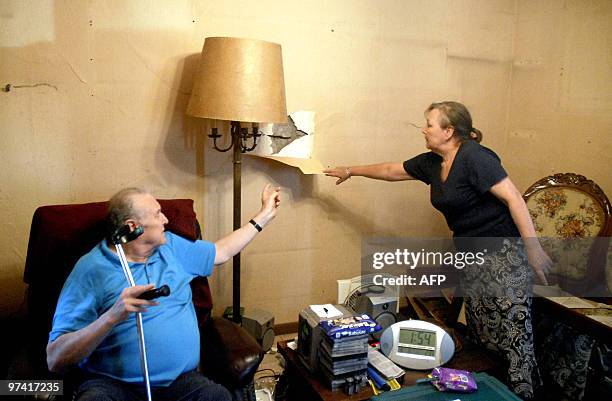 Chilean couple - unable to evacuate their home due to health reasons - observes the damages on their wall, as people camp outside waiting for...