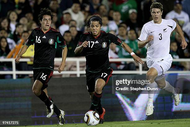 Giovani Dos Santos of Mexico races for the ball in front of teammate Efrain Juarez and Tony Lochhead of New Zealand in an international friendly at...