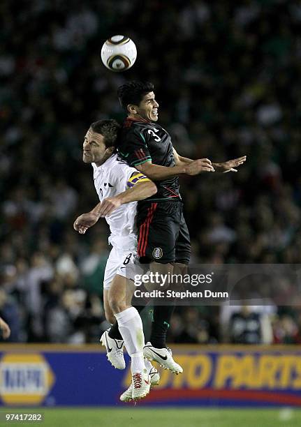 Tim Brown of New Zealand and Carlos Salcido of Mexico jump to battle for the ball in an international friendly at the Rose Bowl on March 3, 2010 in...