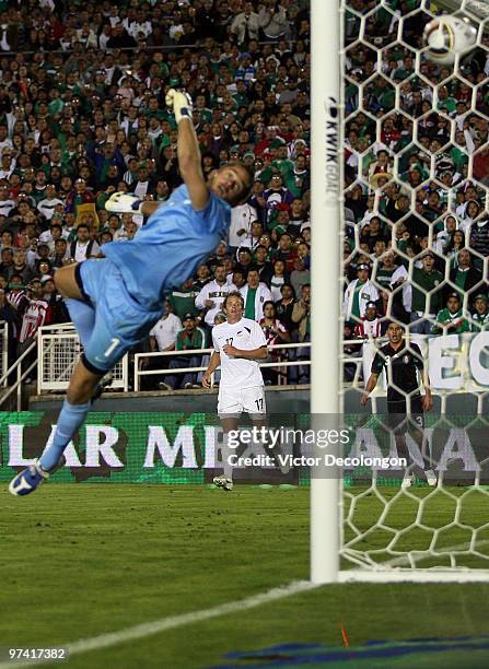 Chad Coombes of New Zealand and Carlos Salcido of Mexico watch as goalkeeper Glen Moss of New Zealand fails to keep the ball out of the net on a shot...