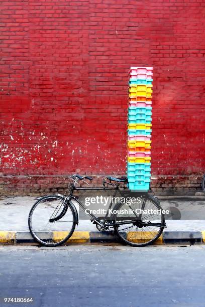 bicycle with stack of plastic containers against red brick wall, kolkata, west bengal, india - kolkata 個照片及圖片檔