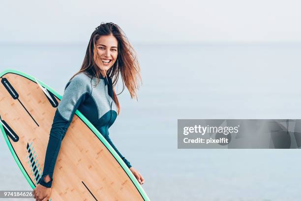 beautiful female surfer, with copy space - surf imagens e fotografias de stock