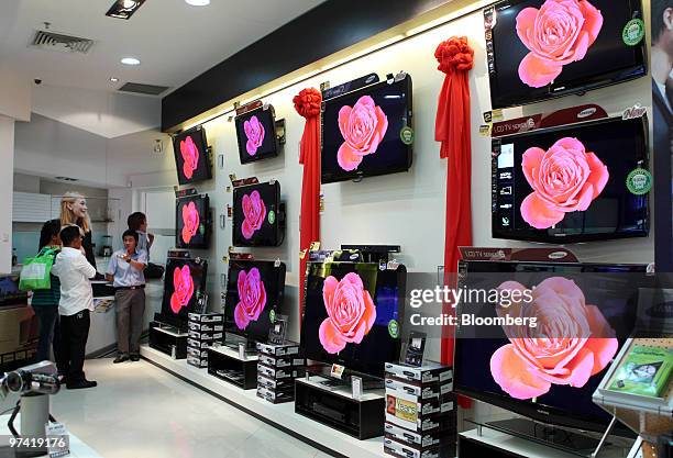 Shoppers look at liquid-crystal display televisions at a store inside Sunway Pyramid mall in Petaling Jaya, Malaysia, on Wednesday, March 3, 2010....