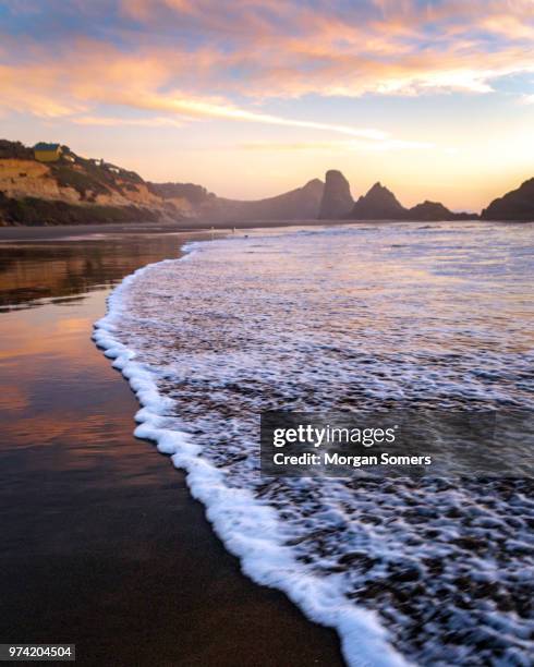piles de mer dans l’océan pacifique pendant le coucher du soleil - côte de l'oregon photos et images de collection